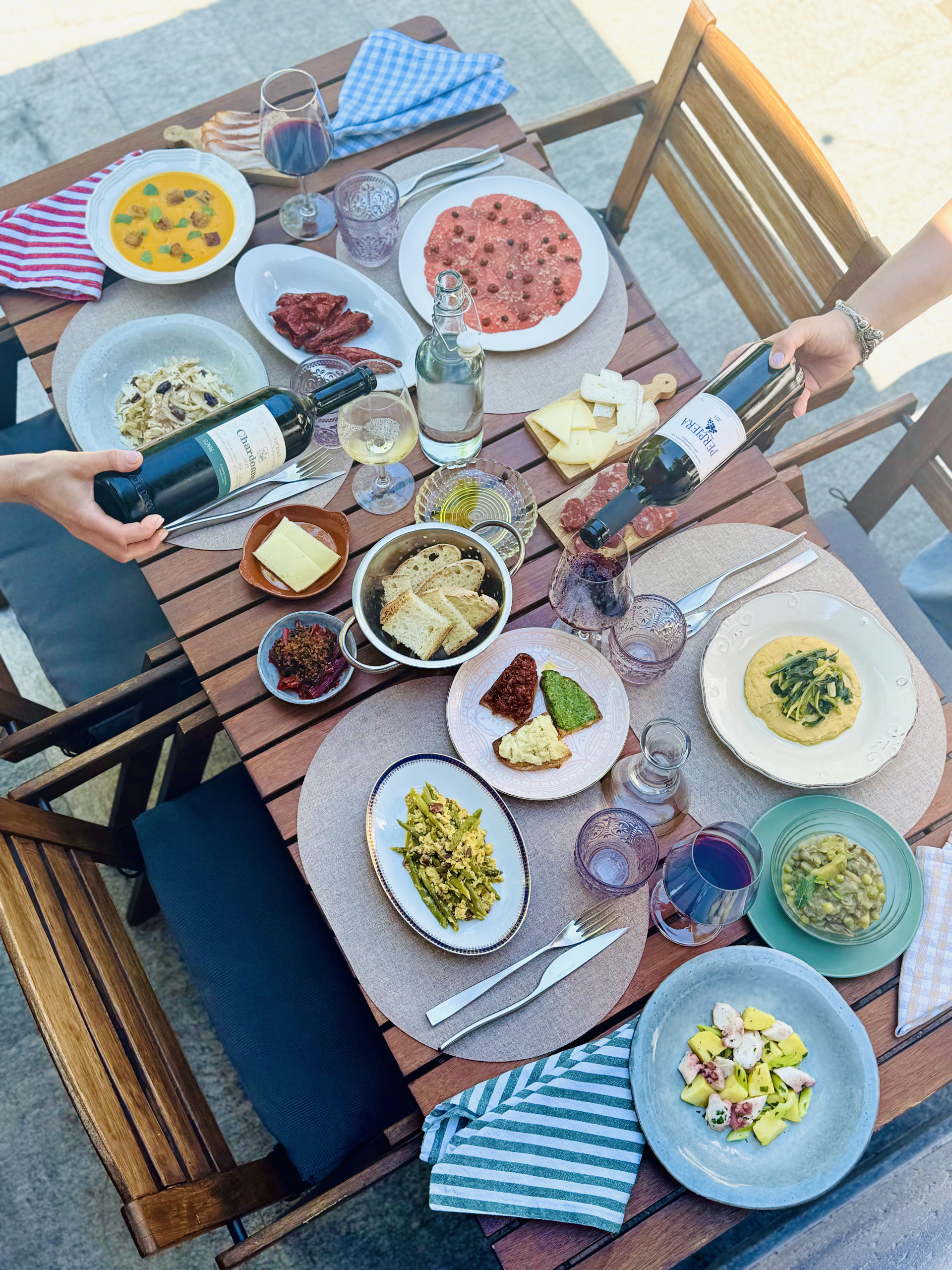 Tavolo in terrazza Tavola in terrazza con piatti di cucina lucana, salumi, formaggi e vino versato nei calici